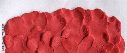 Red colored plasticine texture. Playdough textured background. Abstract rose clay backdrop. Templates of web banner, handmade poster design or label design elements. Natural 3d relief.
