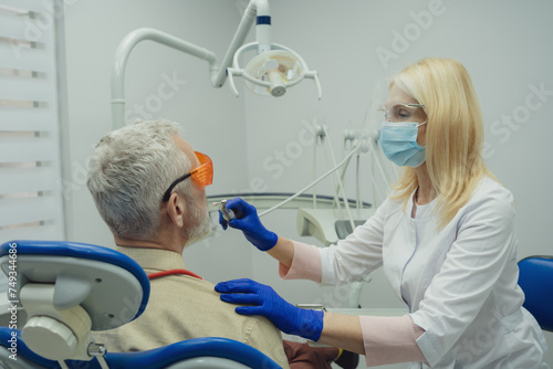 Dental doctor treating a male patient in hospital.