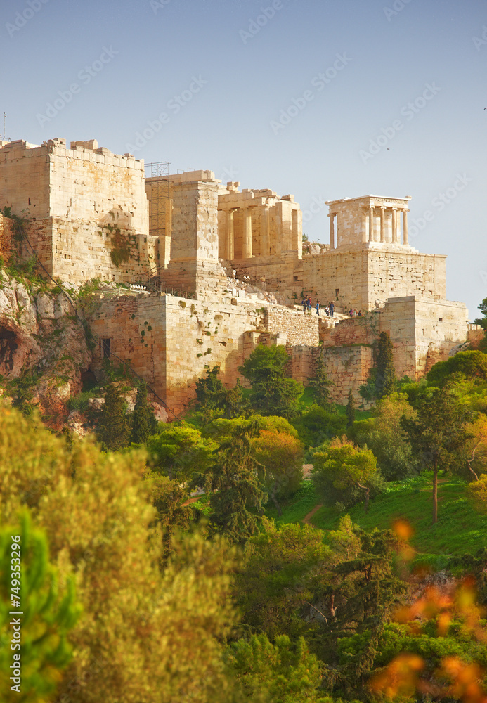 Athens, Greece and building with trees in sunlight, ancient architecture of history site in summer. Marble, stone temple in greek culture with forest landscape, Europe and valley to travel location