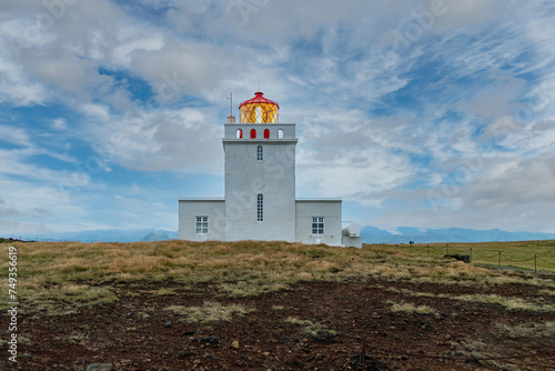 Low angle view of the Dyrhólaey Lighthouse during dusk on the cliffs of Dyrholaey peninsula near Vik, Iceland, the southernmost point in mainland Iceland © Sonja