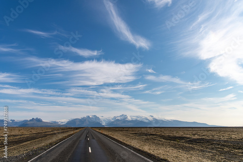 Panoramic view of the Hvannadalshnukur mountain range on the South Coast of Iceland with various glaciers seen from   j    vegur or Route 1 with feathered clouds in blue sky