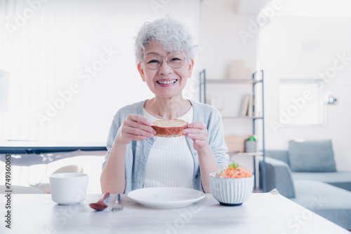 笑顔で朝食を食べるシニアの女性