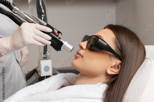 Cosmetologist make laser hair removal on woman s under nose