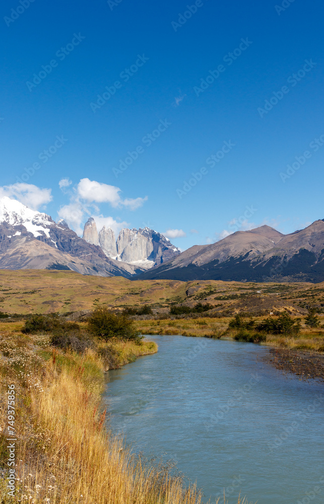 Granite peaks torres seen at a distance with river landscape on a sunny day, national park Torres del Paine, Patagonia, Chile, South America.
