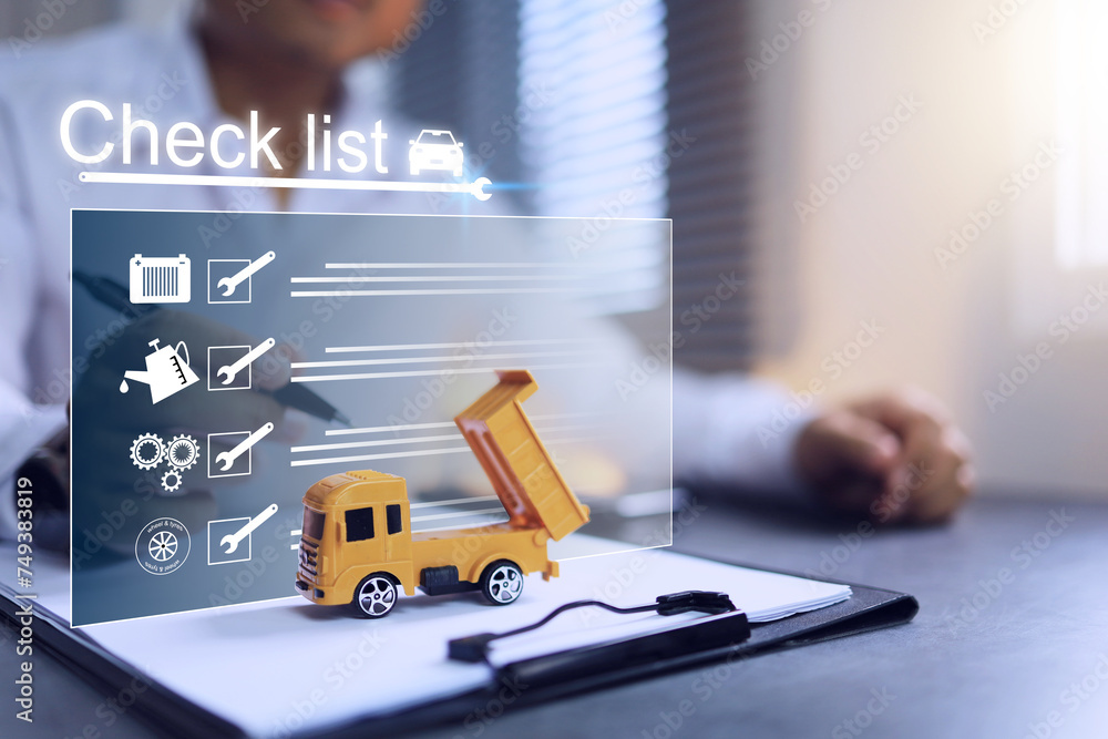 Truck maintenance check list such as changing engine oil Gear oils and other fluids Maintenance of wheels and tires, batteries or engine parts. Staff working with clipboard in office desktop Truck maintenance check list such as changing engine oil Gear oils and other fluids Maintenance of wheels and tires, batteries or engine parts. Staff working with clipboard in office desktop
