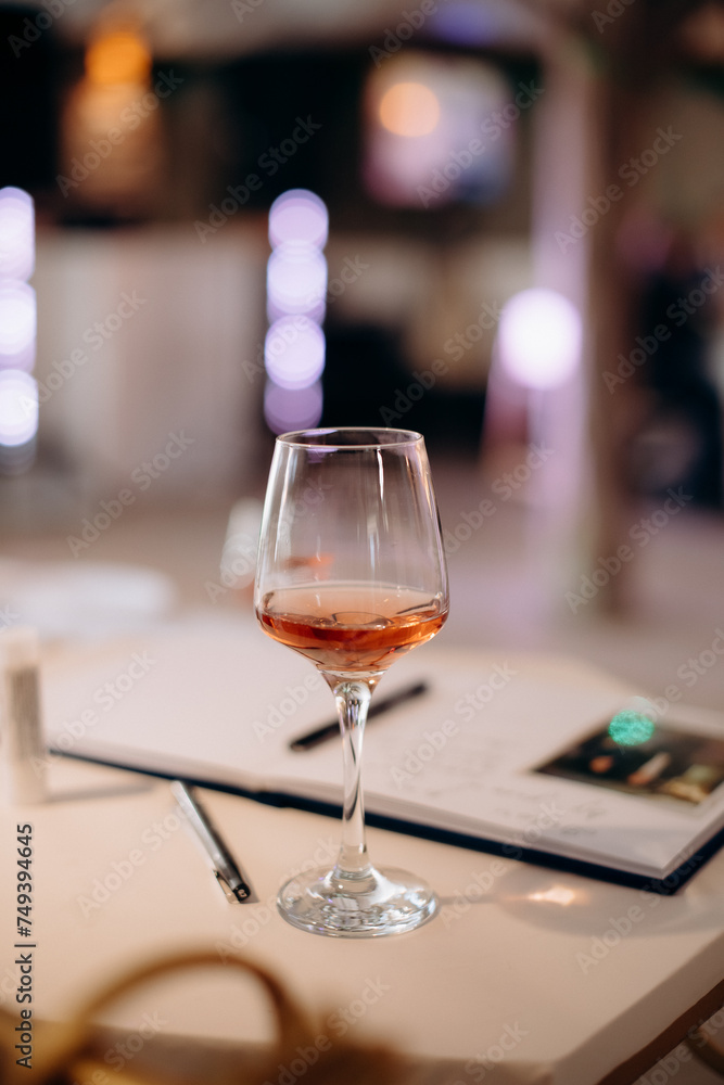 Fototapeta premium A small tasting glass of sparkling champagne. An unfinished glass of alcohol. Drink champagne or a cocktail. A dirty glass