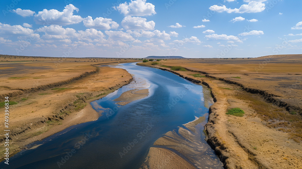 An aerial view of a river reduced amidst a barren landscape, illustrating the severe effects of prolonged drought and climate change.
