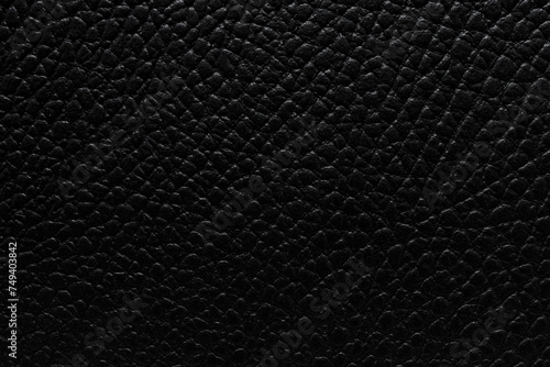 Close-up of black pebbled leather texture, showing intricate details perfect for luxury and fashion backgrounds.