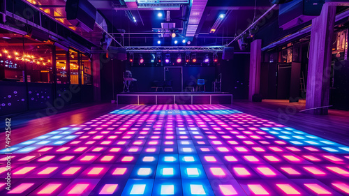 An empty dance floor bathed in neon lights, eagerly awaiting the rhythm and movement of a night full of dance and music. © praewpailyn
