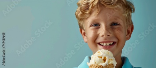 A young boy is happily eating a large vanilla ice cream cone.