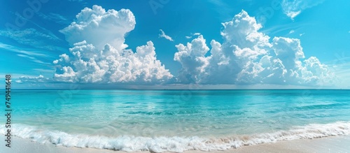 A view of the ocean with clouds scattered across the sky, creating a dynamic contrast of blue and white elements in the scene.