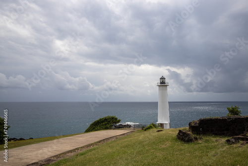 Le Phare du Vieux-Fort, white lighthouse on a cliff. Dramatic clouds overlooking the sea. Pure Caribbean on Guadeloupe, French Antilles, France