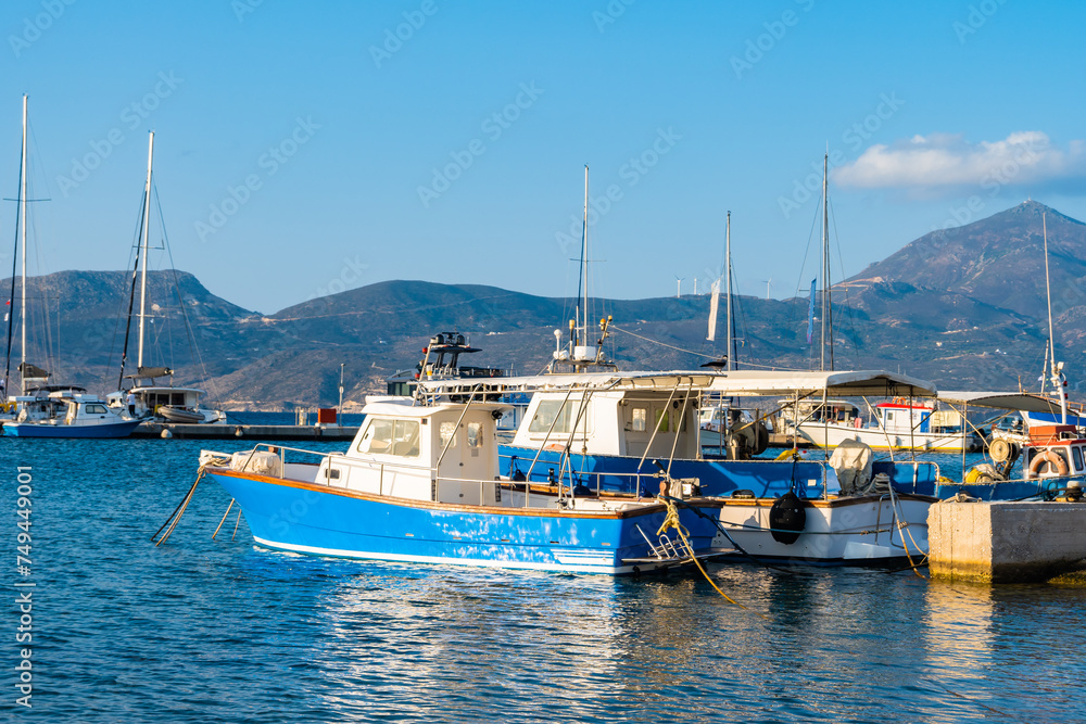 Traditional Greek fishing boats on blue sea in Adamas port bay, Milos island, Cyclades, Greece