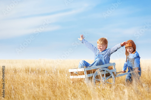 Children play planes in a field on a summer sunny day.