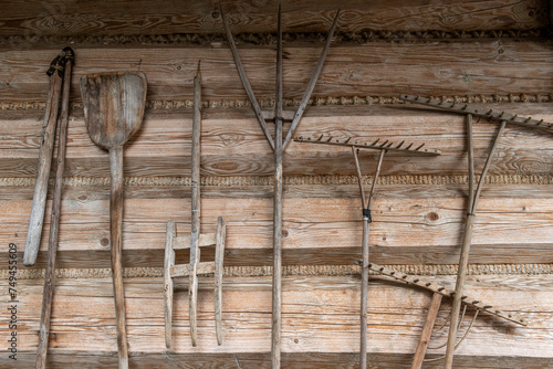 Drewniane narzędzia rolnicze na tle ściany wiejskiej drewnianej chaty