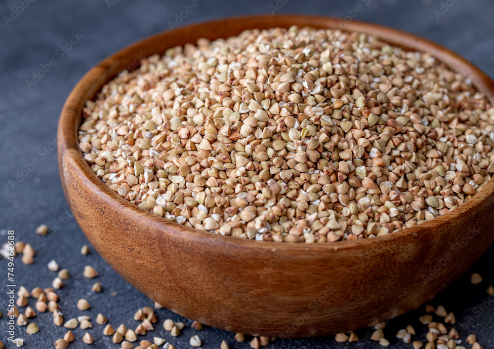 Organic Raw Buckwheat Groats in a Wooden Bowl. Healthy Eating Concept. View from Above. Organic Raw Buckwheat Groats in a Wooden Bowl. Healthy Eating Concept. View from Above.