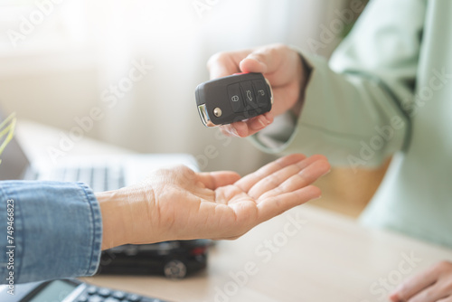 Business car rental, sell service, dealership hand of agent dealer, sell asian young woman giving auto key of vehicle to customer renter, female buyer receiving, client or tenant, transfer automobile.