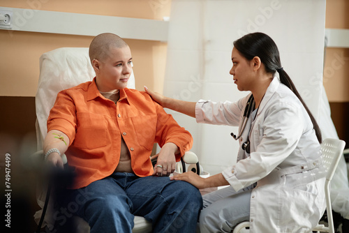 Canvastavla Side view portrait of young nurse comforting cancer patient receiving chemothera