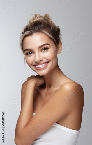 Beautiful model woman with clear facial tan healthy skin and a big pretty smile on her face light white gray background