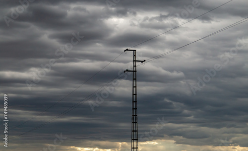 Pilón de la red eléctrica rural con un cielo nublado de tormenta. Distribución de electricidad en el mundo rural. El Granado, Huelva, Spain. photo