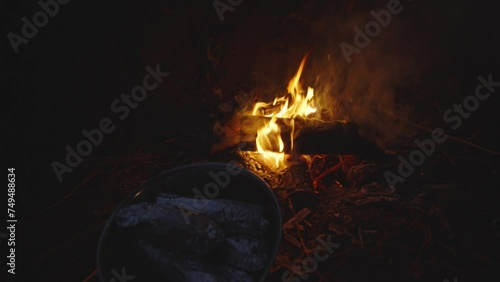 オレンジの炎を上げる焚き火とアルミホイルに包まれた焼き芋　キャンプ　バーベキュー photo