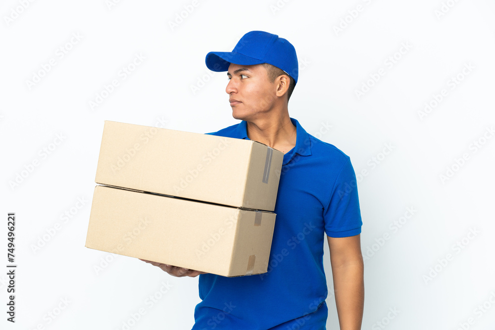 Delivery Ecuadorian man isolated on white background looking to the side Delivery Ecuadorian man isolated on white background looking to the side
