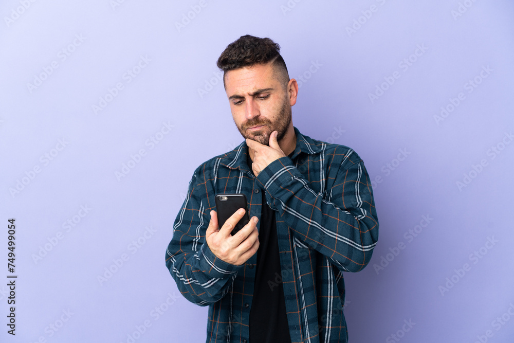 Caucasian man isolated on purple background thinking and sending a message Caucasian man isolated on purple background thinking and sending a message