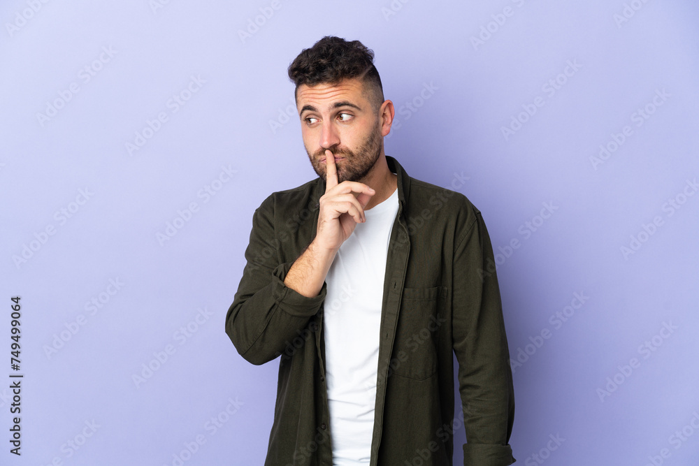 Caucasian man isolated on purple background showing a sign of silence gesture putting finger in mouth Caucasian man isolated on purple background showing a sign of silence gesture putting finger in mouth