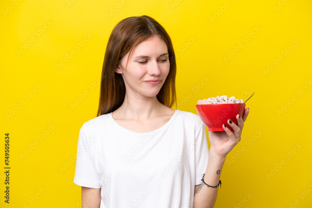 Young English woman holding cup of coffee isolated on yellow background with happy expression Young English woman holding cup of coffee isolated on yellow background with happy expression