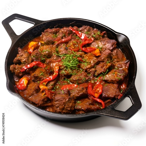 Sizzling beef stir-fry with red chili peppers and herbs in a cast-iron skillet