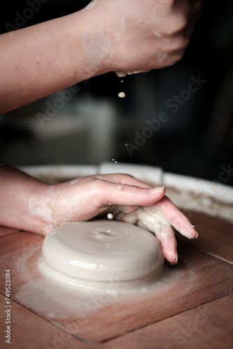 Unrecognizable Ceramics Maker working with Pottery Wheel in Cozy Workshop Adding Water to Future Vase or Mug, Creative People Handcraft Pottery Class