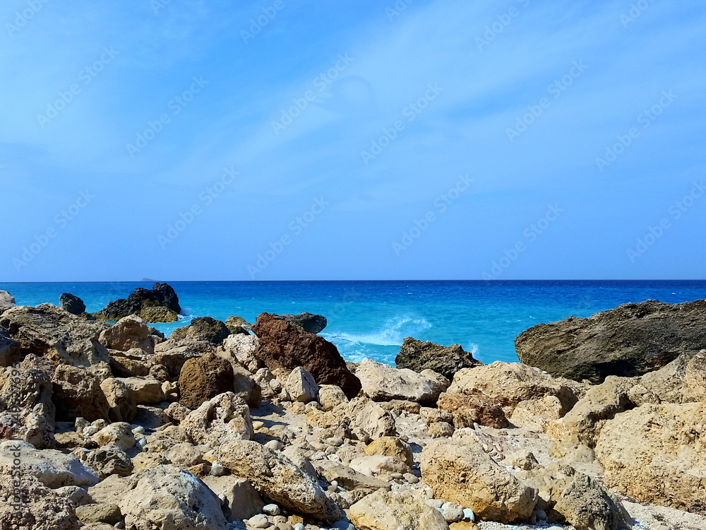 View of splashing white waves in beach rocks and cliffs. Turquoise azure, tropical sea water