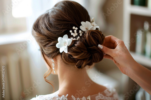 Elegant Bridal Hairstyle with Delicate Floral Accessories. A stylist perfects a sophisticated updo adorned with white flowers and pearls