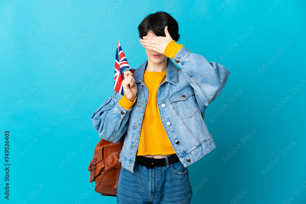 Woman holding an United Kingdom flag over isolated background covering eyes by hands. Do not want to see something Woman holding an United Kingdom flag over isolated background covering eyes by hands. Do not want to see something