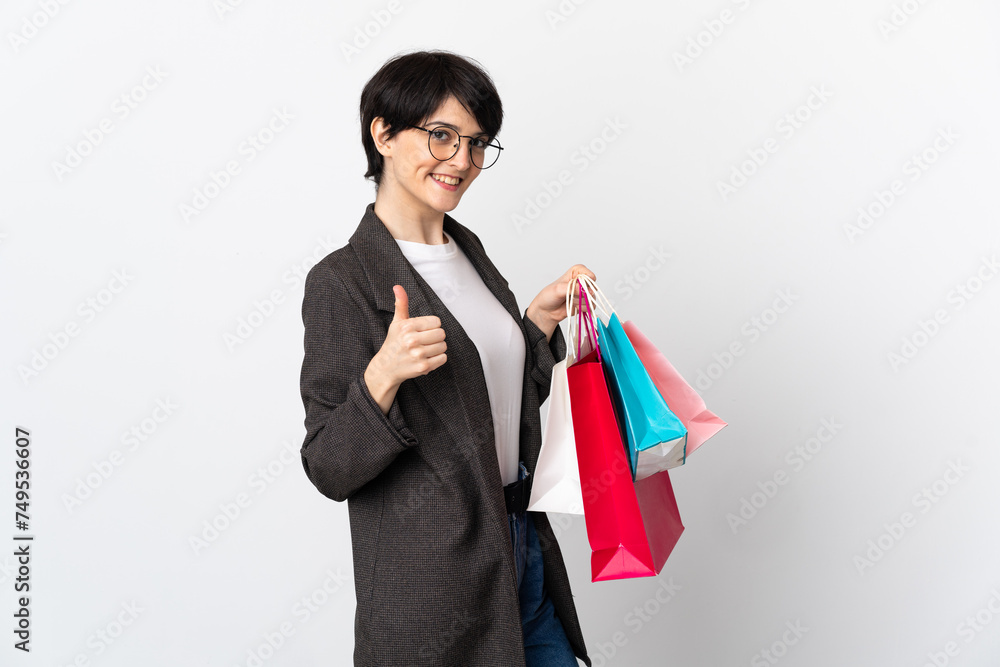 Woman with short hair isolated on white background holding shopping bags and with thumb up Woman with short hair isolated on white background holding shopping bags and with thumb up