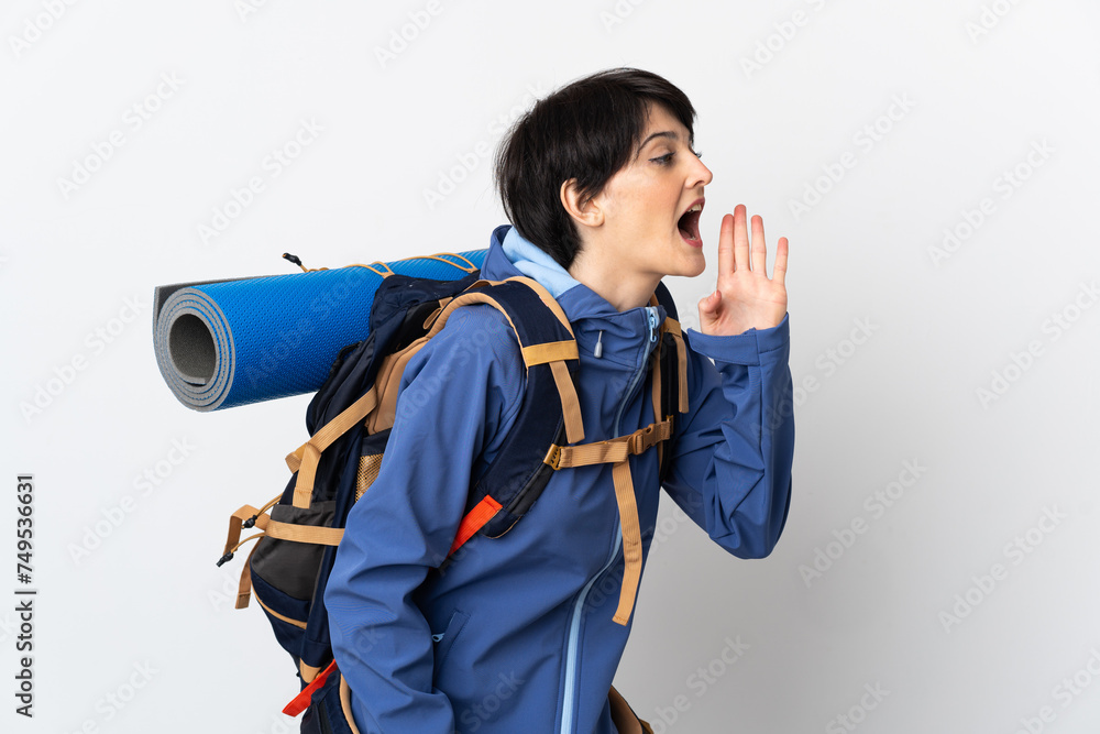 Mountaineer woman over isolated background shouting with mouth wide open to the side Mountaineer woman over isolated background shouting with mouth wide open to the side