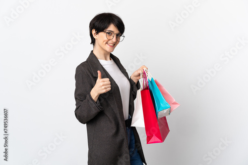 Woman with short hair isolated on white background holding shopping bags and with thumb up