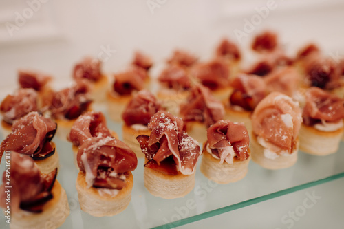 Food, a beautifully decorated catering banquet table with a variety of appetizers with cheese, ham, prosciutto and fruit. At a corporate, Christmas, birthday or wedding celebration. Buffet table. Buff