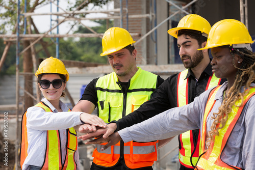 Group of male and female engineer construction working and join hands together at construction site. Foreman construction working at construction site photo
