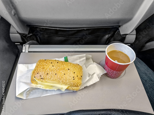 Snack during a flight with a Turkish airline between Turkish cities. Bun with cheese and coffee on board the airplane photo