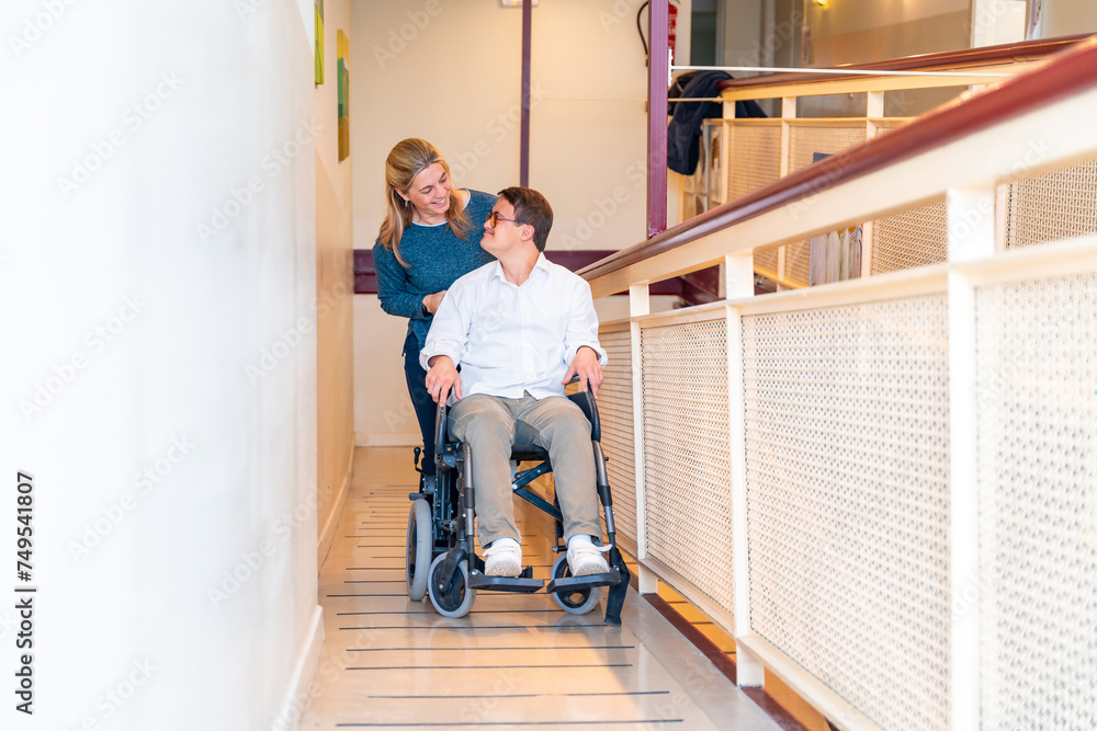 Kind nurse and disabled man talking while using wheelchair