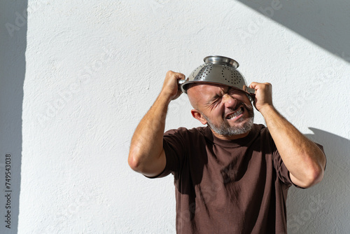 bearded cheerful man with a colander on his head. cheerful portraits of a man with a colander