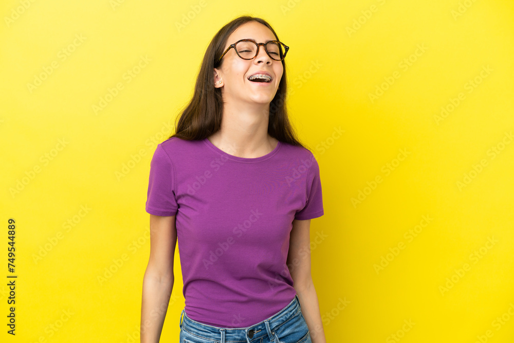 Young French woman isolated on yellow background laughing Young French woman isolated on yellow background laughing