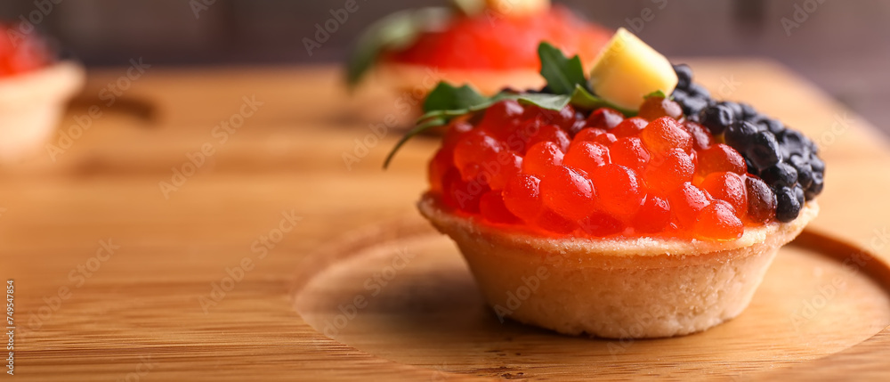 Tasty tartlet with caviar on wooden board, closeup - obrazy, fototapety, plakaty 