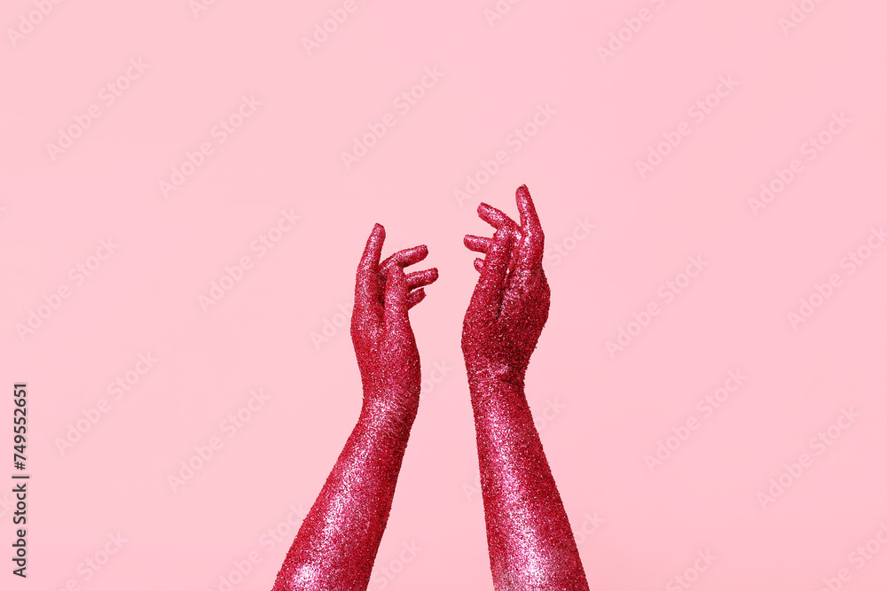 Female hands covered with glitter on pink background, closeup Female hands covered with glitter on pink background, closeup