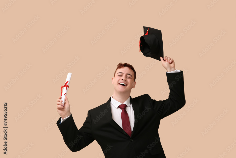 Male student with mortar board and diploma on beige background Male student with mortar board and diploma on beige background