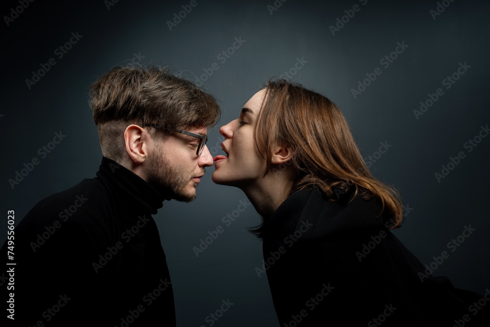 The woman licked the nose of the man standing in front of her with her tongue. The woman licked the nose of the man standing in front of her with her tongue.