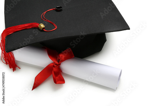 Mortar board and diploma on white background