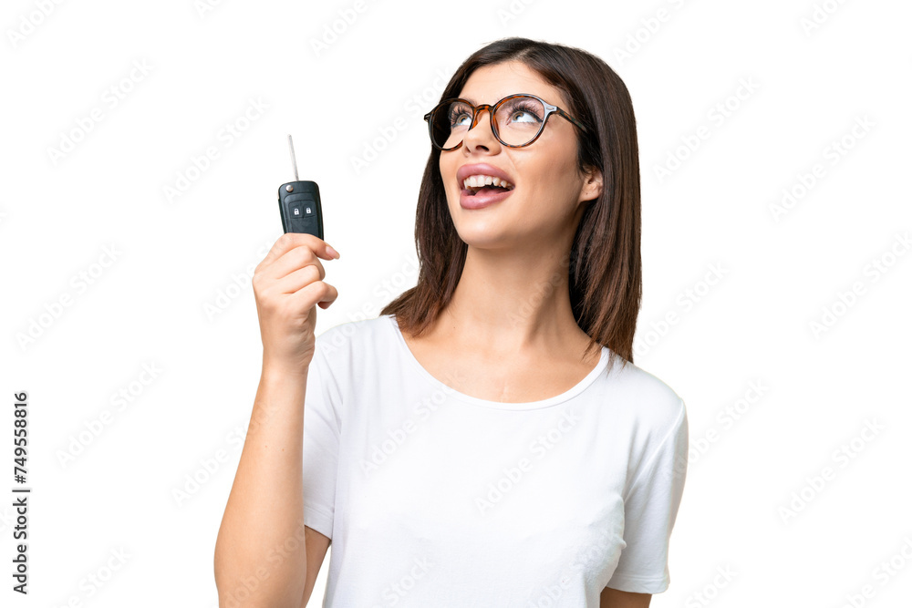 Young Russian woman holding car keys over isolated chroma key background looking up while smiling Young Russian woman holding car keys over isolated chroma key background looking up while smiling