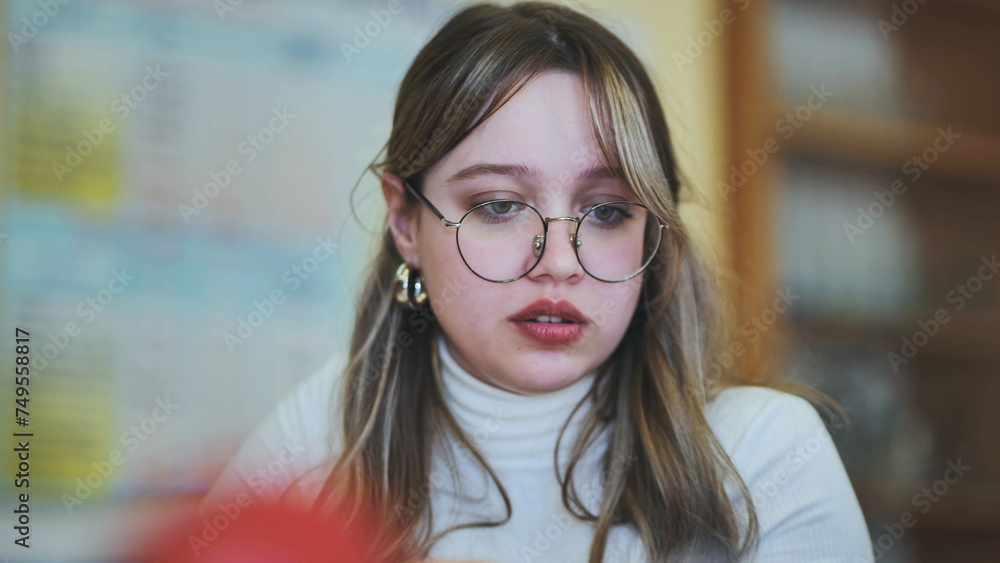 Schoolgirl with glasses at her desk at school. Schoolgirl with glasses at her desk at school.